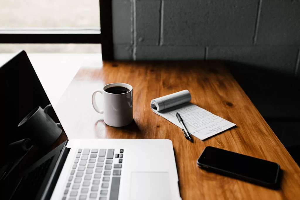 Writing with a notepad and laptop